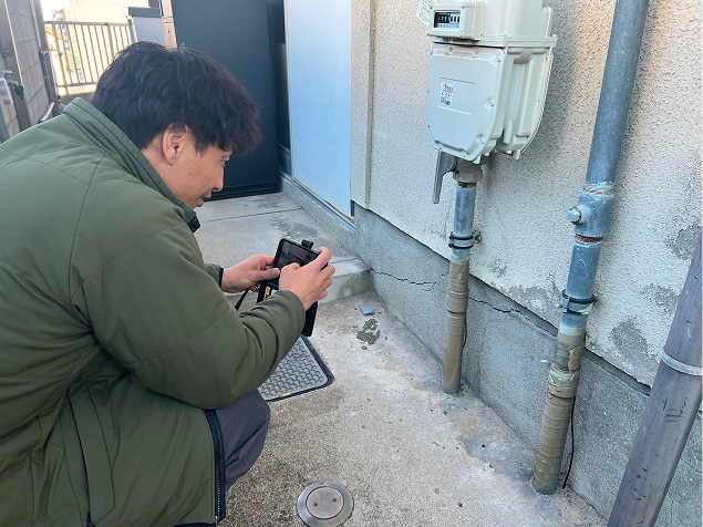 雨樋を撮影している調査員のイメージ写真。