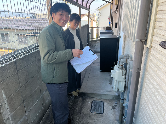 雨樋を撮影している調査員のイメージ写真。