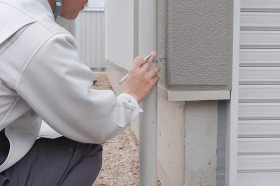 調査員の男性が高所棒を使って調査しているイメージの写真。