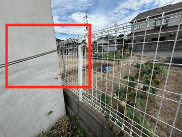 物置が倒れたことでフェンスが破損。ロープで縛っている状態。